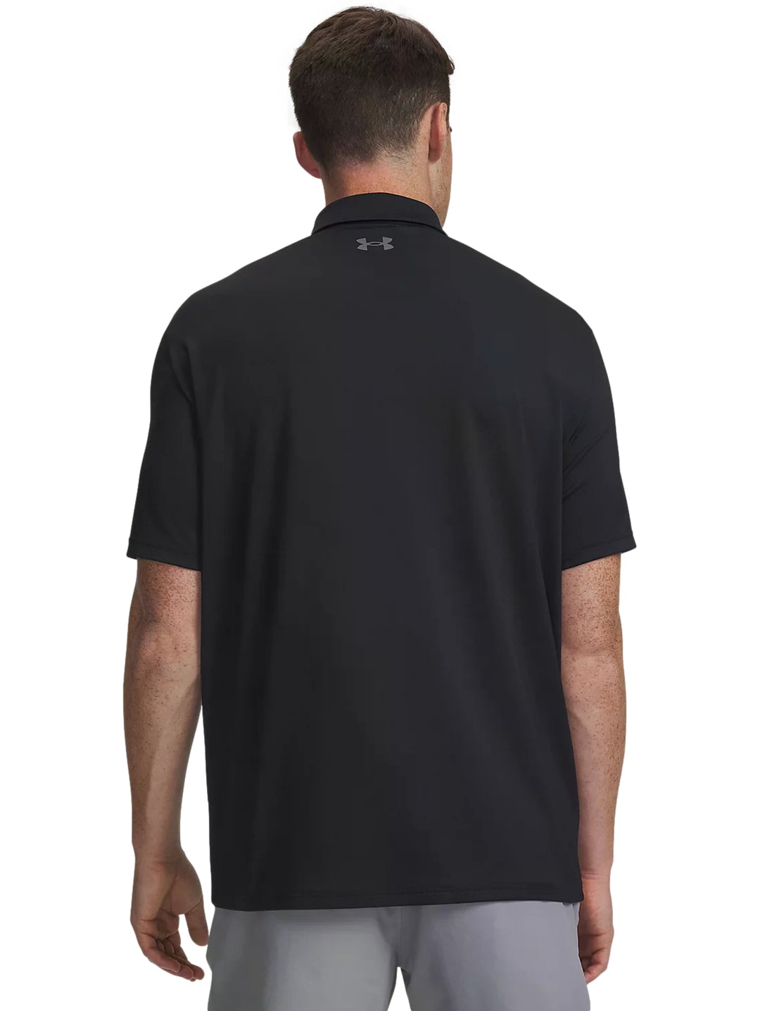 Hombre vistiendo playera polo Under Armour color negro de manga corta.