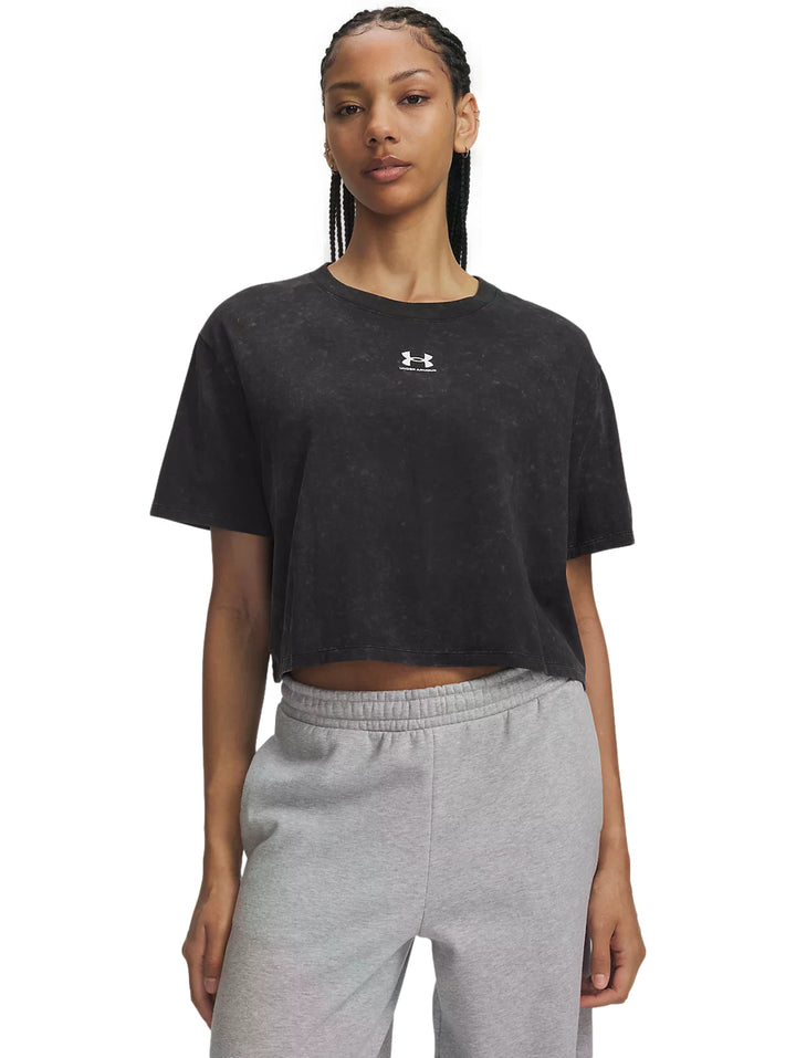 Mujer vistiendo playera negra Under Armour Rival Boxy Tee Wash con efecto lavado.