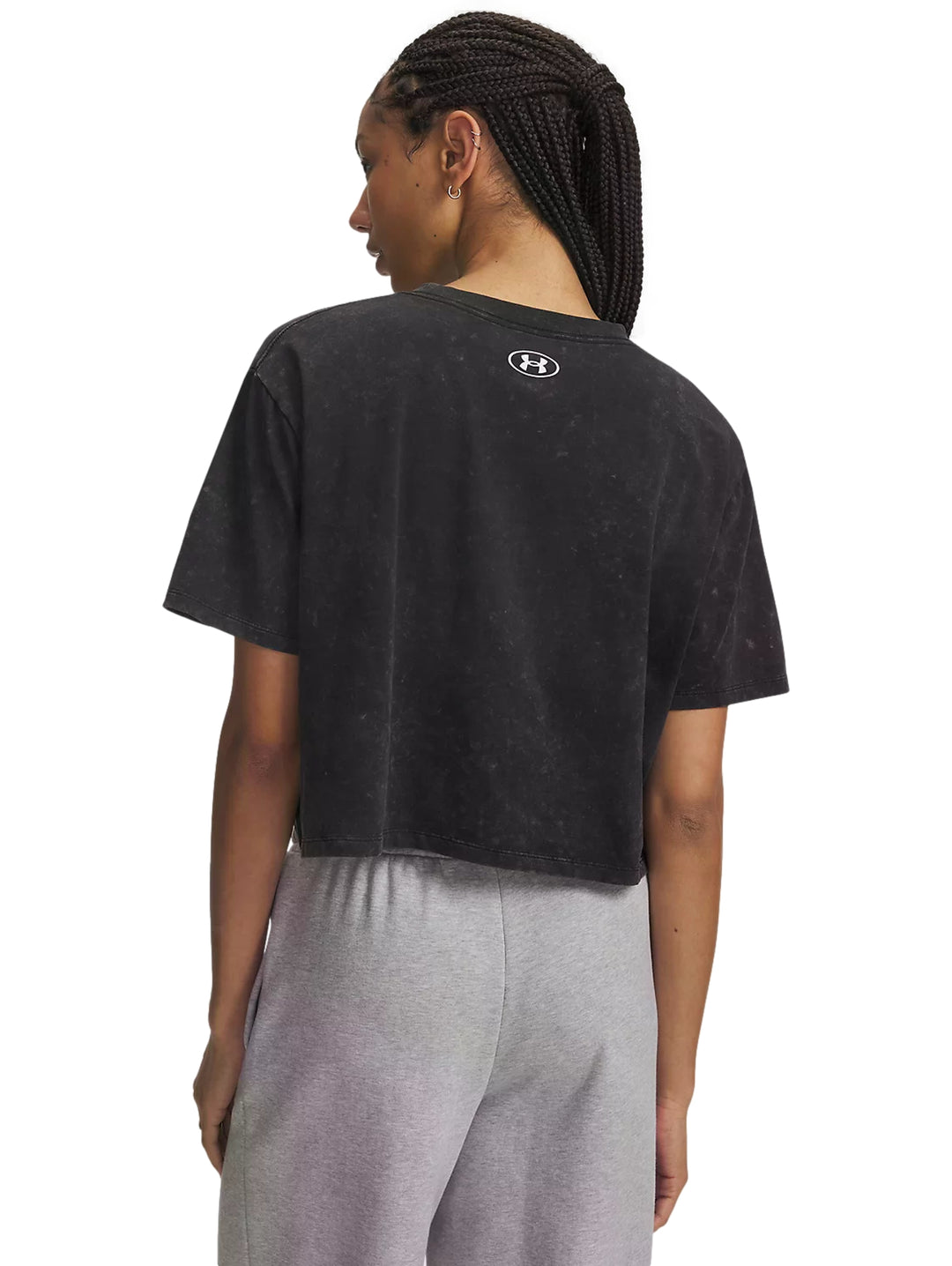 Mujer vistiendo playera negra Under Armour Rival Boxy Tee Wash con efecto lavado.