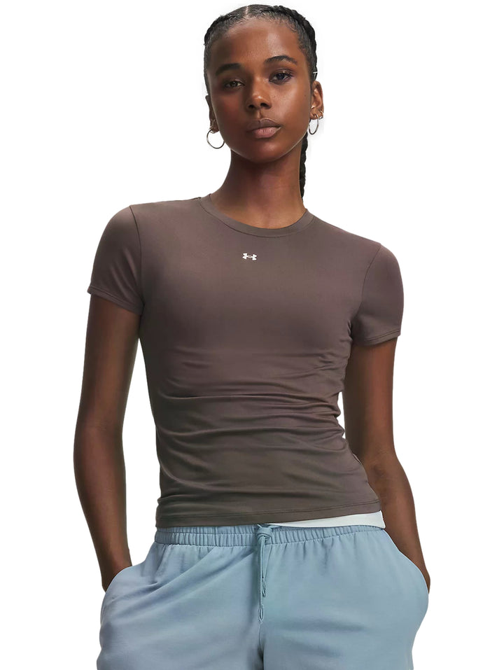 Mujer vistiendo playera deportiva Under Armour ajustada color pimienta y pantalones azul claro.