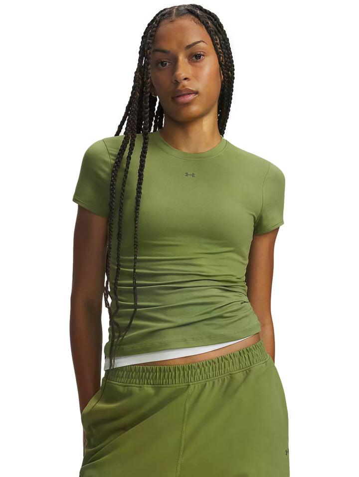 Mujer vistiendo playera deportiva ajustada de color verde oliva de la marca Under Armour.