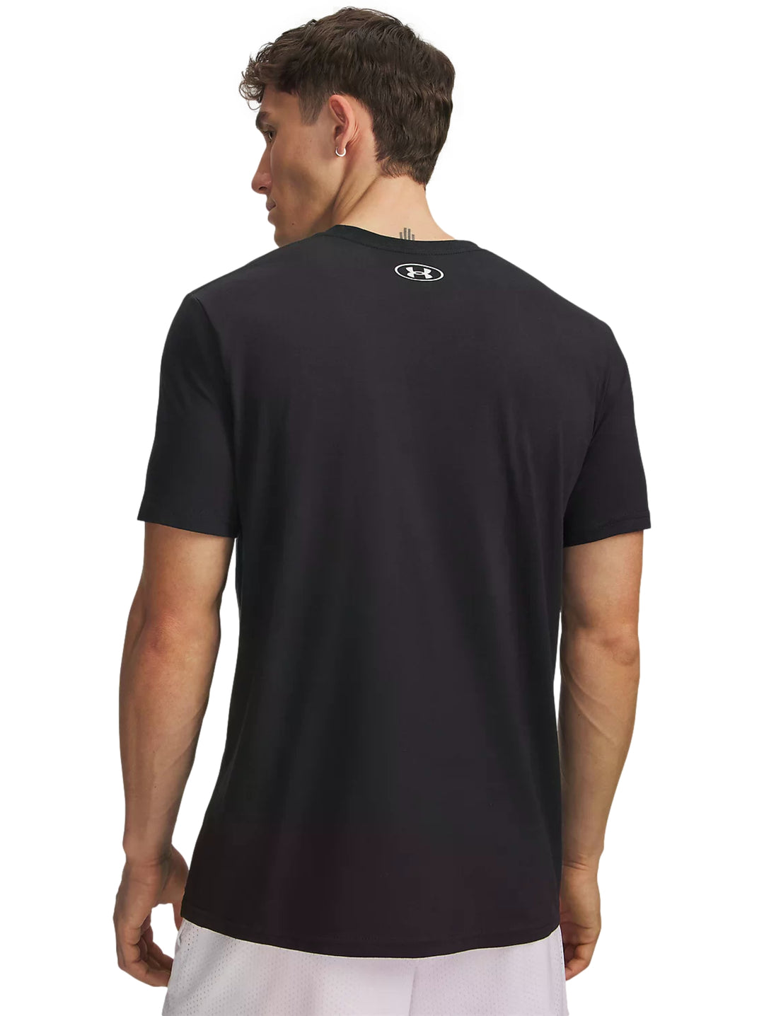 Hombre vistiendo playera deportiva Under Armour color negro con logotipo en el pecho en rojo y blanco.