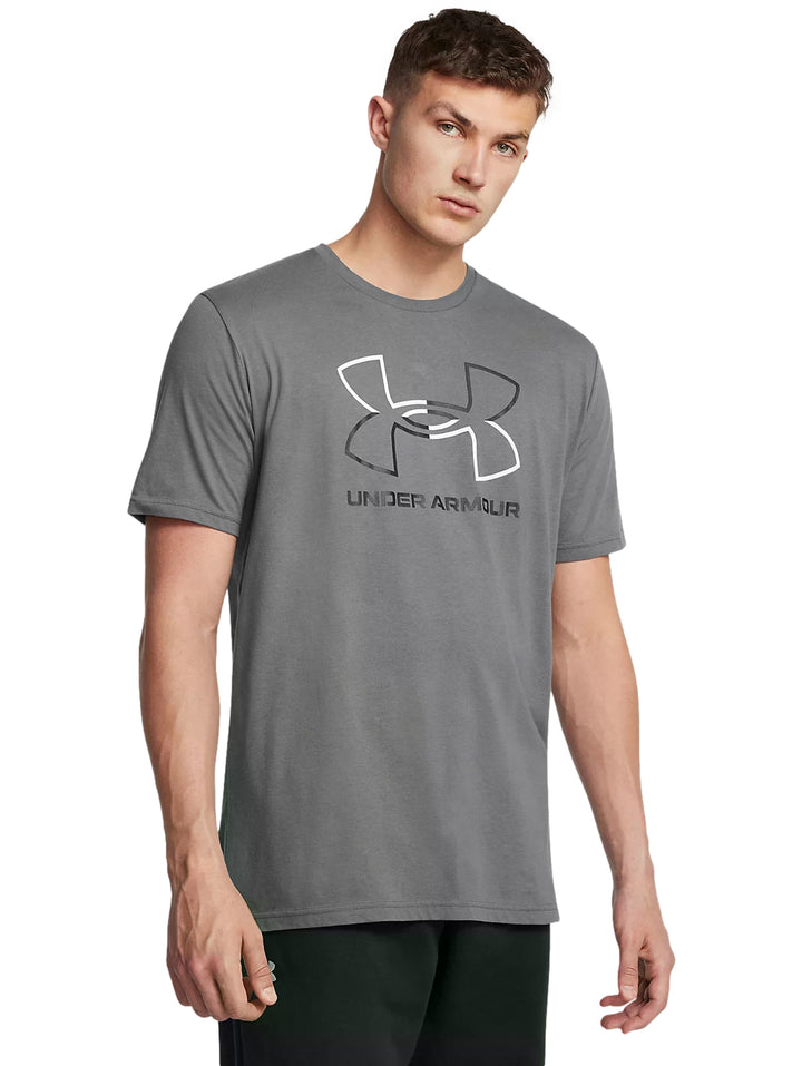 Hombre vistiendo playera deportiva Under Armour color gris con logotipo en el pecho.
