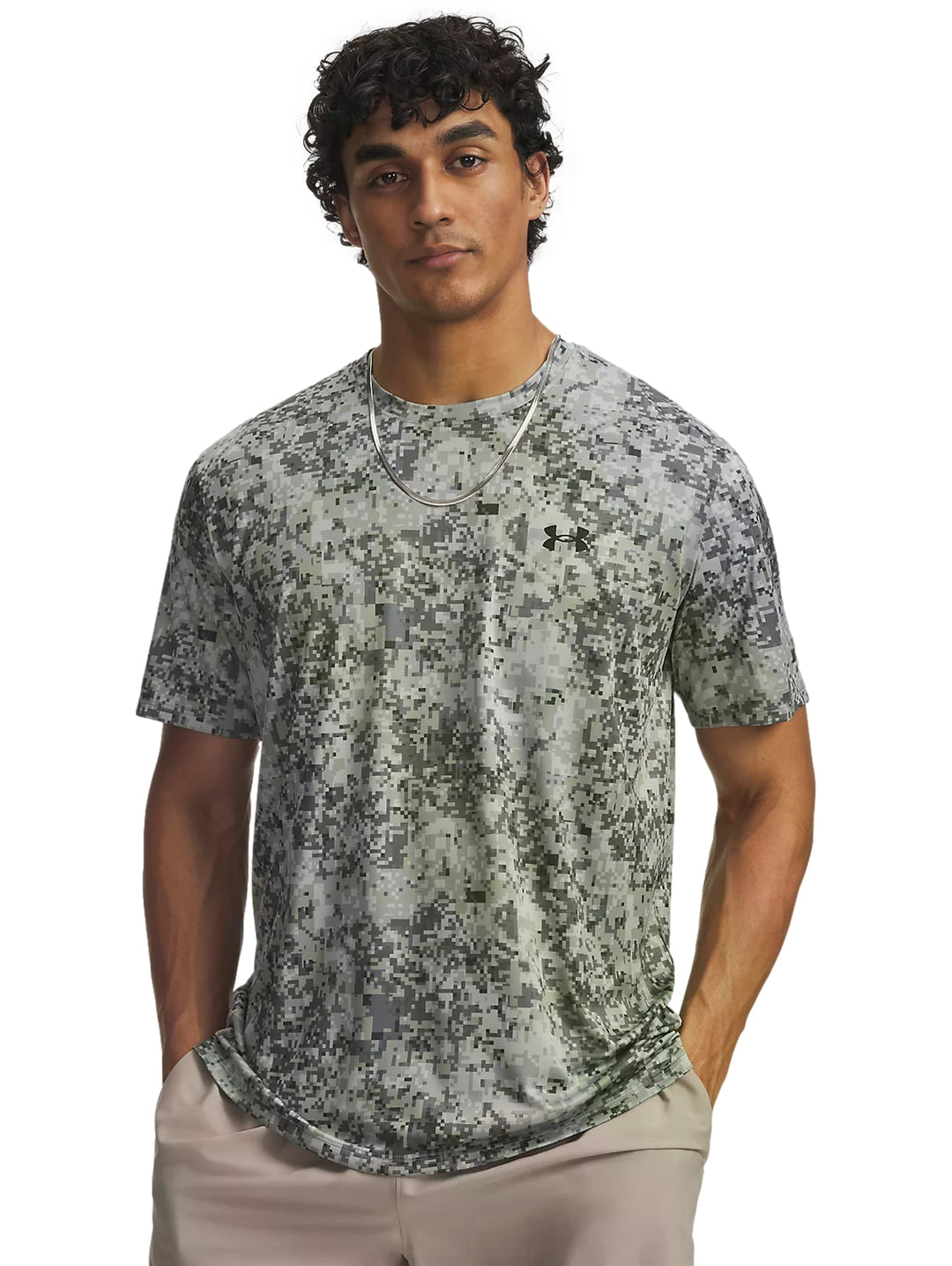 Hombre vistiendo playera Under Armour color titanio con estampado de camuflaje digital.