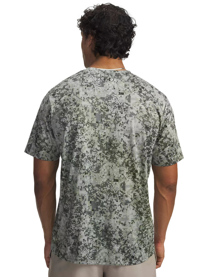 Hombre vistiendo playera Under Armour color titanio con estampado de camuflaje digital.