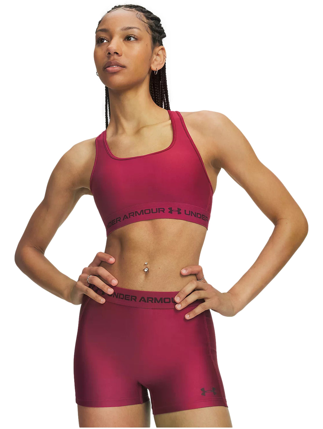 Mujer vistiendo un top deportivo Under Armour color claret con banda elástica en la base.