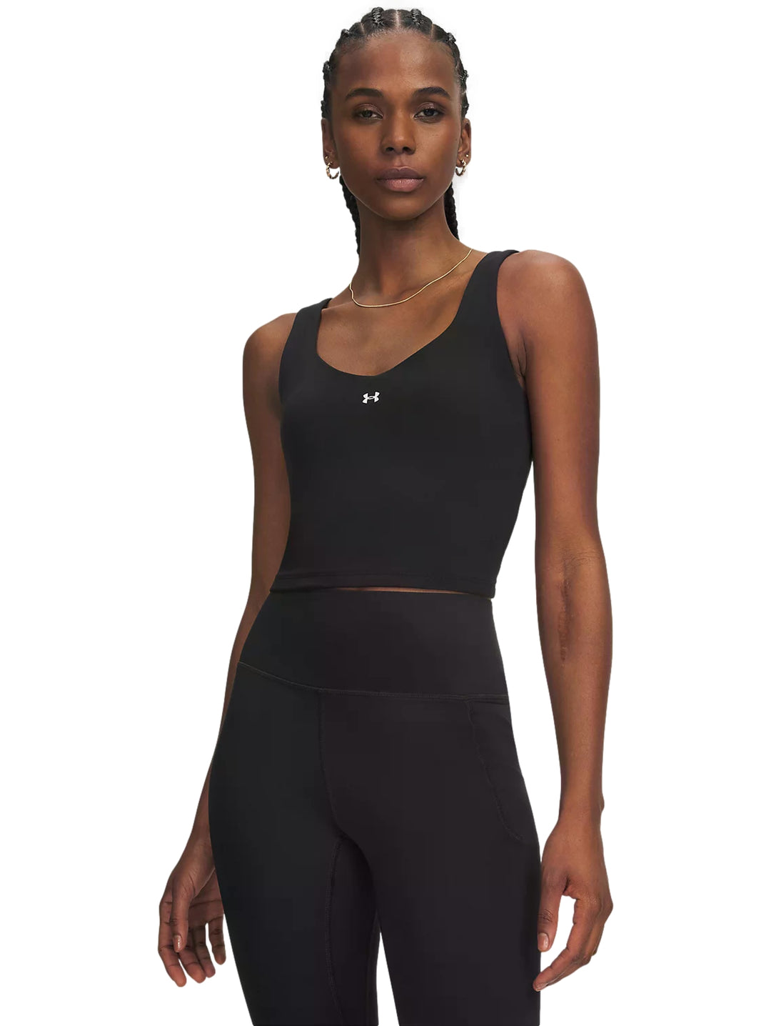Mujer vistiendo un top corto deportivo color negro de la marca Under Armour.
