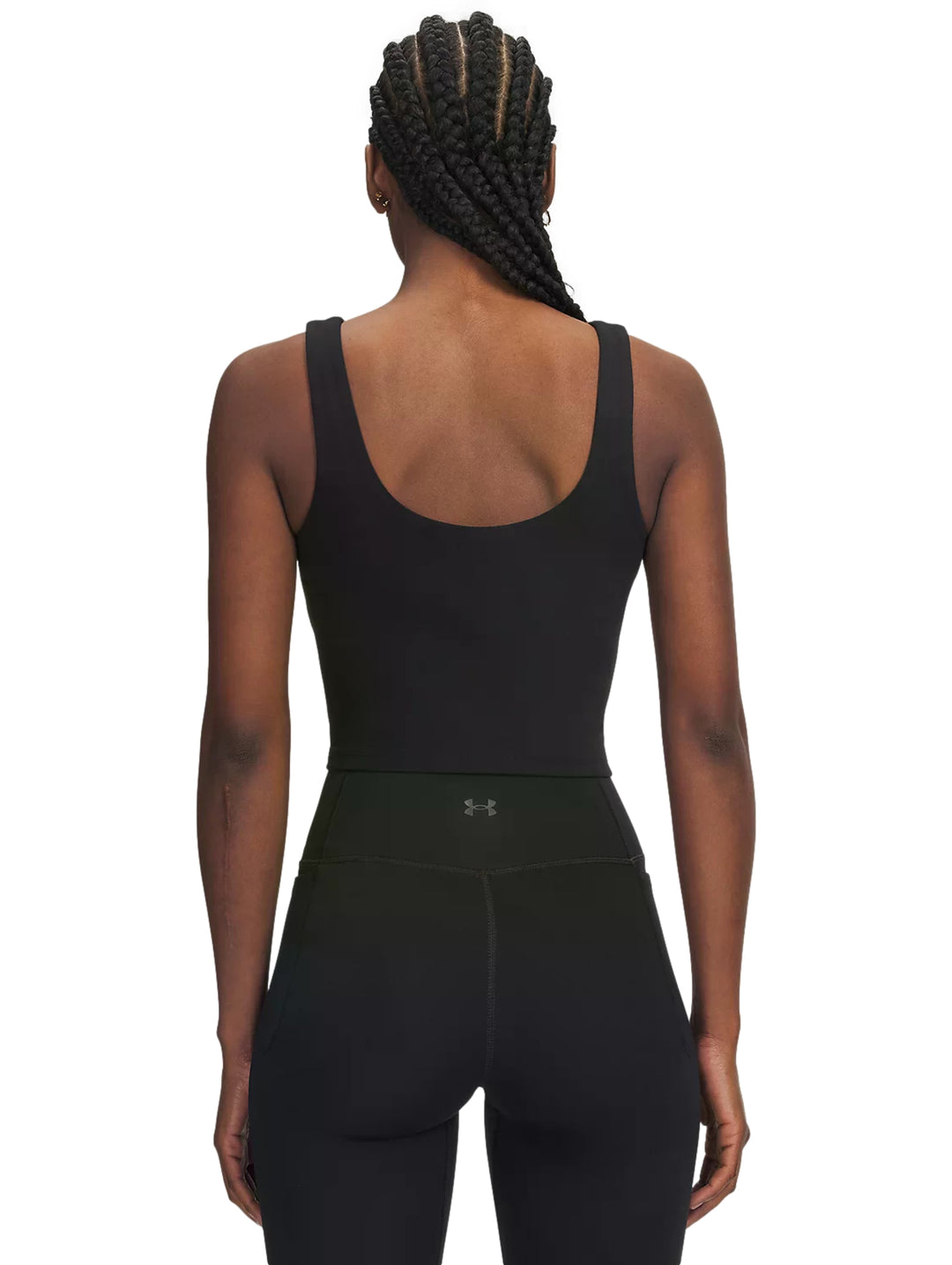 Mujer vistiendo un top corto deportivo color negro de la marca Under Armour.