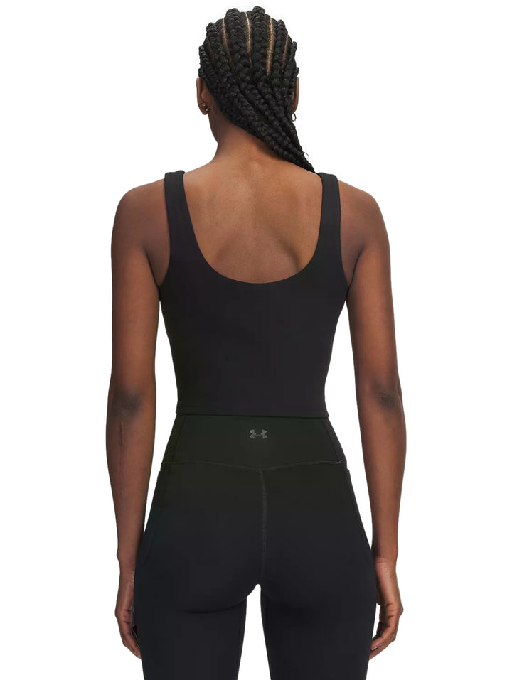 Mujer vistiendo un top corto deportivo color negro de la marca Under Armour.