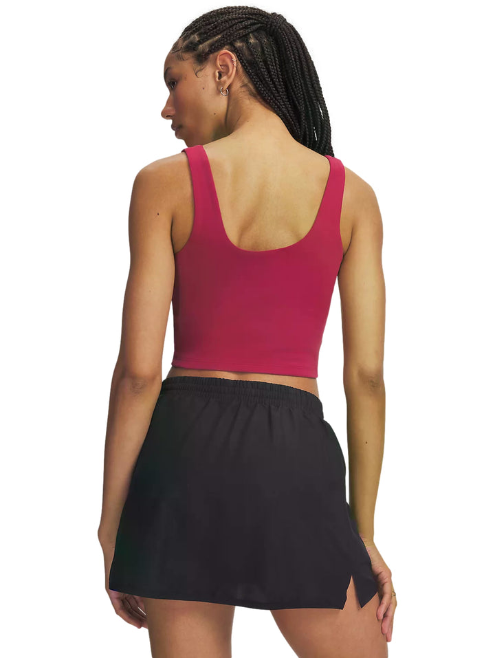 Mujer vistiendo un top corto deportivo color claret de la marca Under Armour.