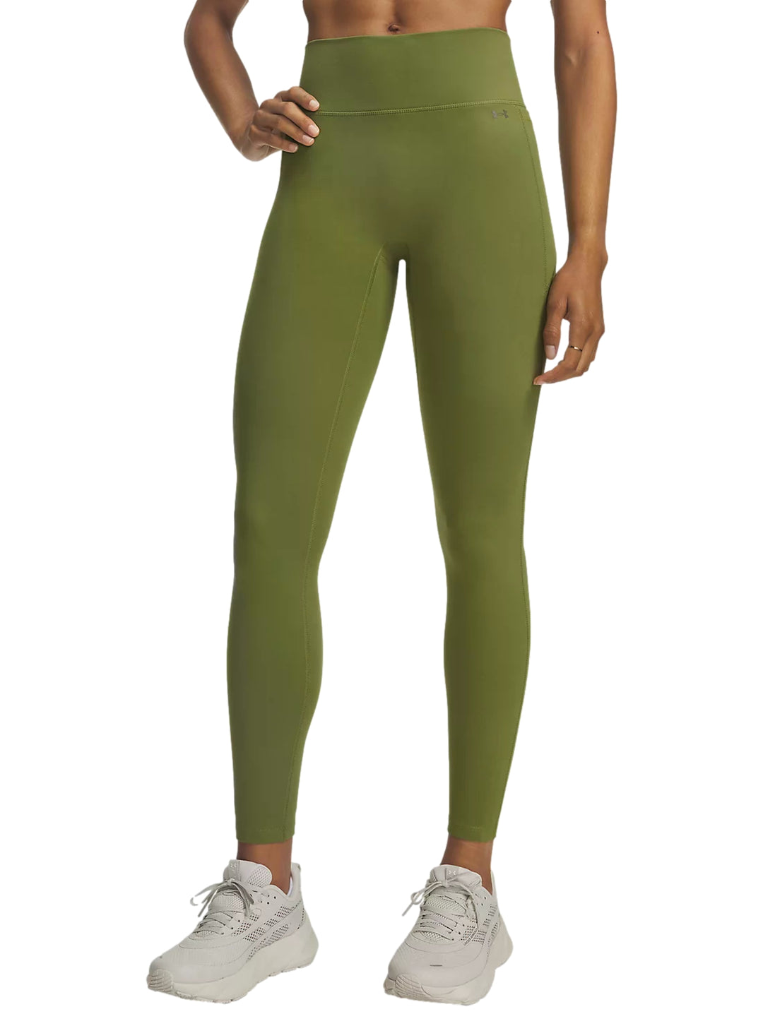 Mujer vistiendo leggings deportivos Under Armour color olivo largo 7/8 y tenis blancos.