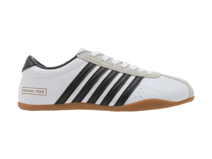Tenis K-Swiss Misaki V blancos con rayas negras laterales y suela de goma color café.