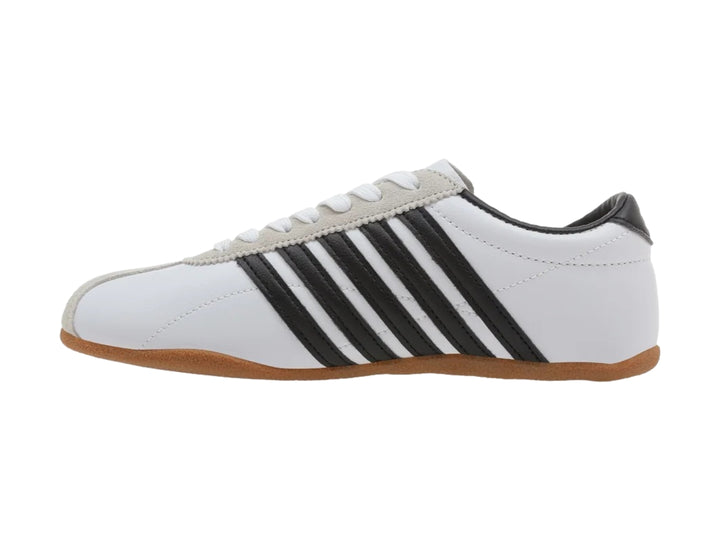Tenis K-Swiss Misaki V blancos con rayas negras laterales y suela de goma color café.