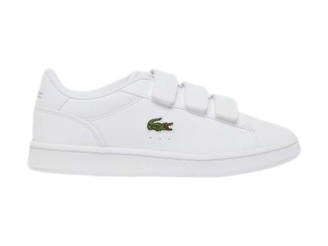 Tenis Lacoste blancos de cuero con cierre de velcro y logotipo del cocodrilo en verde.