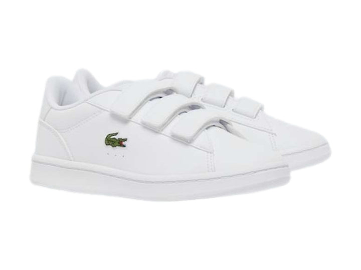 Tenis Lacoste blancos de cuero con cierre de velcro y logotipo del cocodrilo en verde.