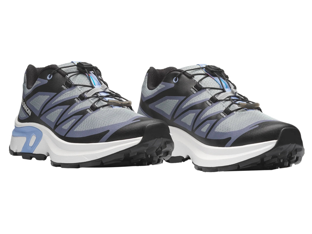 Tenis deportivos Salomon XT-EVR color gris y negro con suela blanca y detalles azul claro.