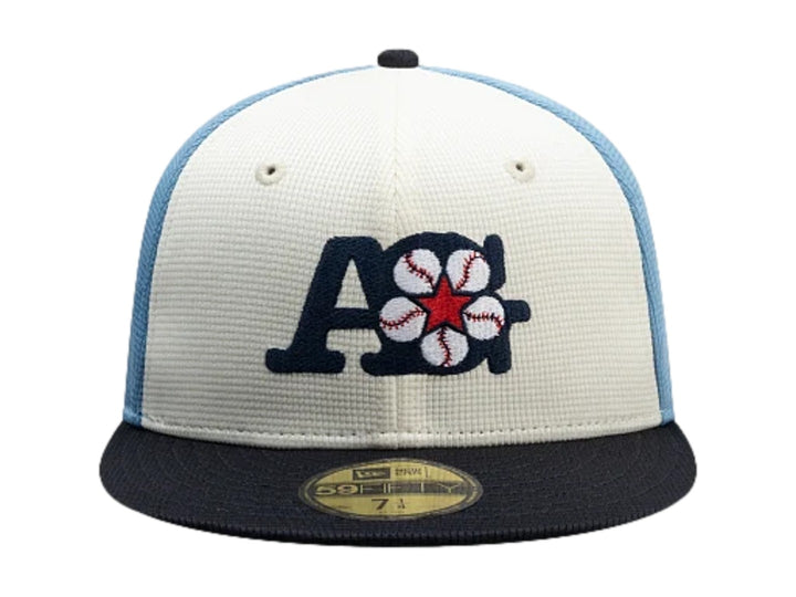 Gorra New Era 59Fifty con visera marino, paneles blanco y azul claro, y bordado frontal decorativo.