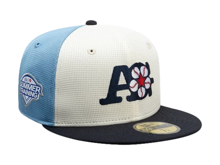 Gorra New Era 59Fifty con visera marino, paneles blanco y azul claro, y bordado frontal decorativo.