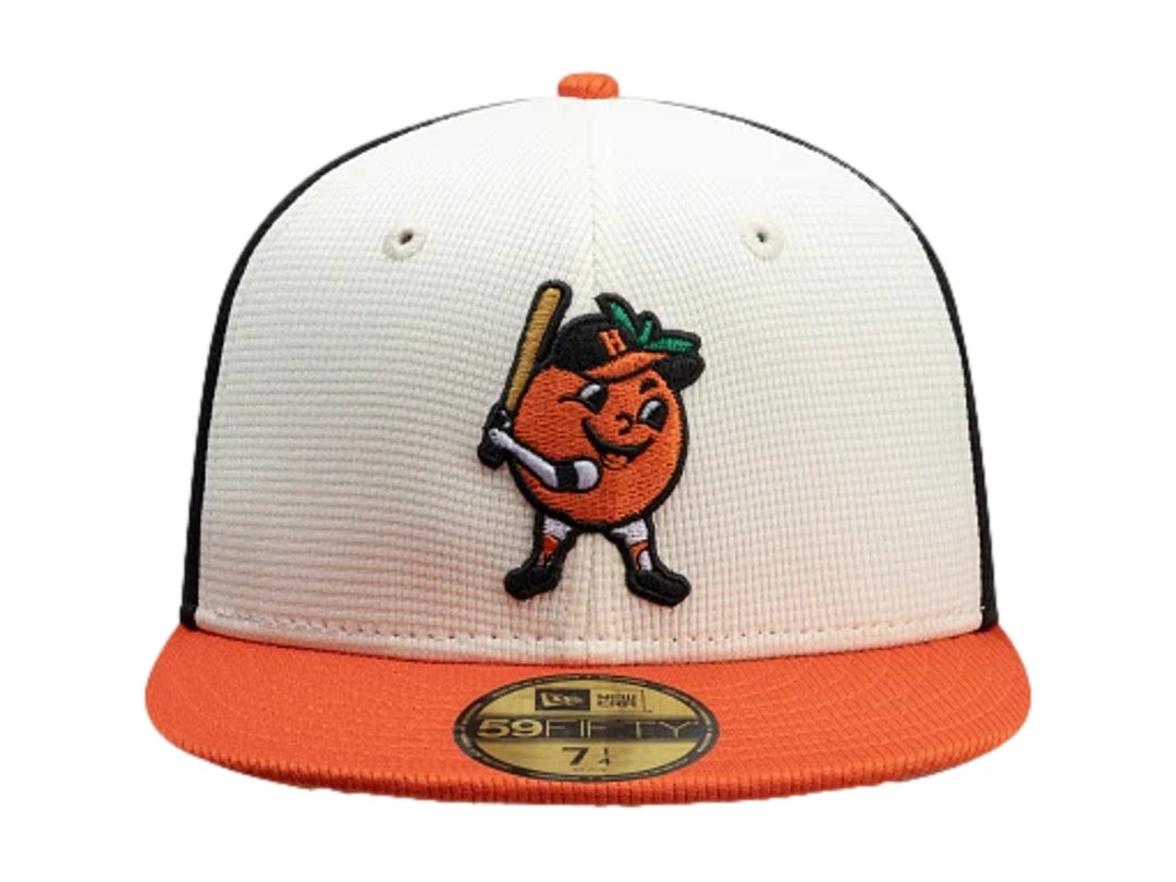 Gorra New Era 59Fifty con paneles blanco y negro, visera naranja y bordado frontal de personaje de béisbol.