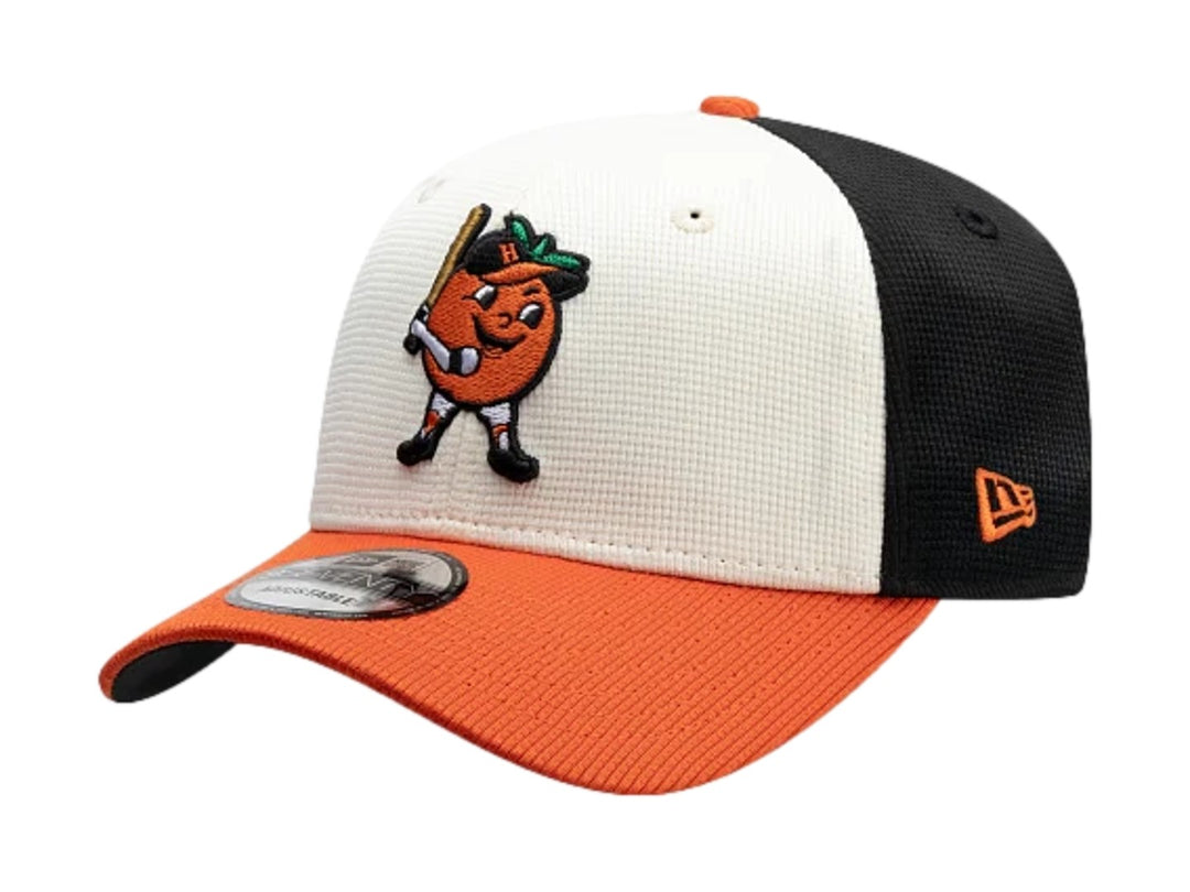 Gorra New Era tricolor en negro, blanco y naranja con bordado de personaje en el frente.