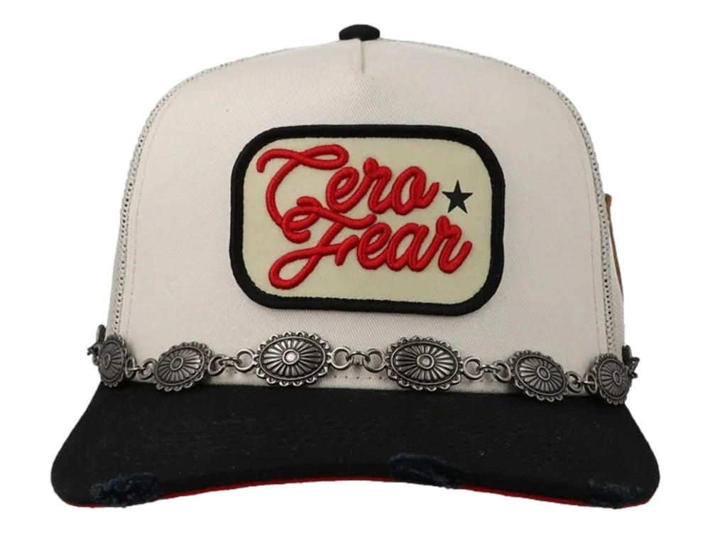 Gorra snapback beige y negra con parche bordado 'Cero Fear' y detalle de cadena metálica sobre la visera.