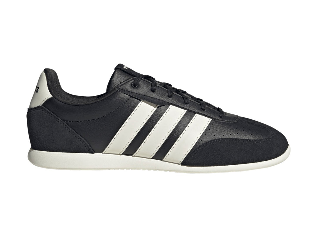 Tenis Adidas Barreda color negro con tres franjas blancas laterales y suela blanca.