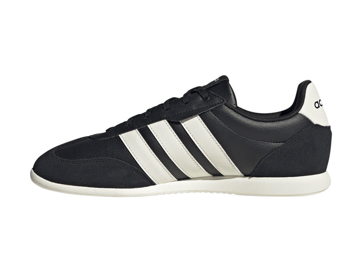 Tenis Adidas Barreda color negro con tres franjas blancas laterales y suela blanca.