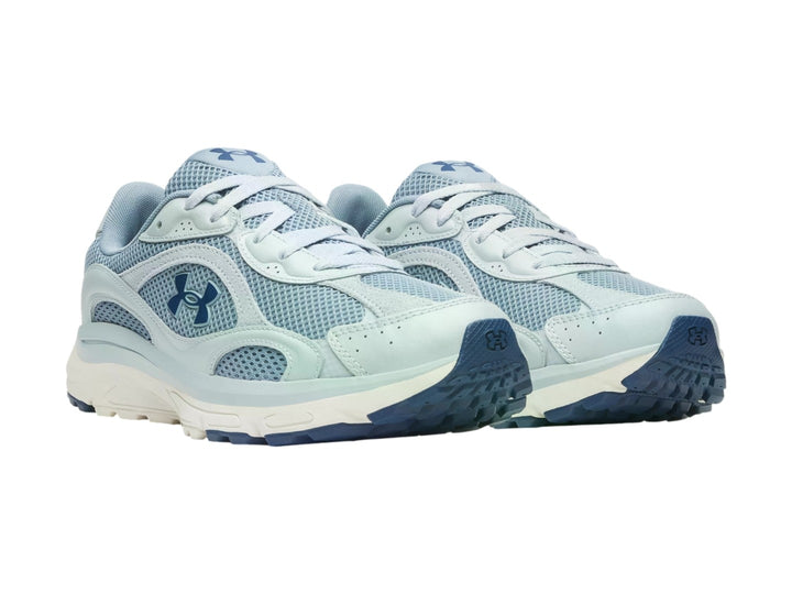 Tenis Under Armour Tech Runner en color azul claro y blanco con detalles en malla y suela blanca.
