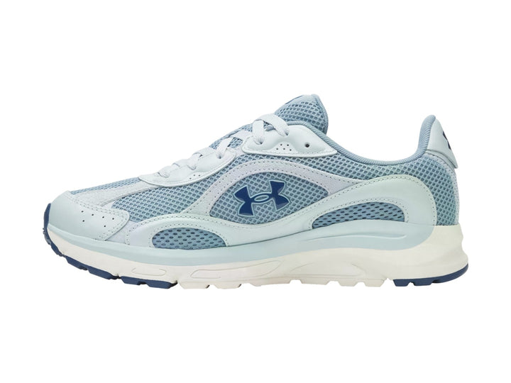 Tenis Under Armour Tech Runner en color azul claro y blanco con detalles en malla y suela blanca.