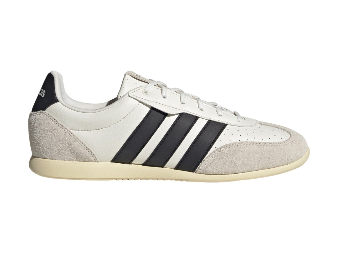 Tenis Adidas Barreda color blanco con tres franjas negras laterales y detalles en gamuza beige.