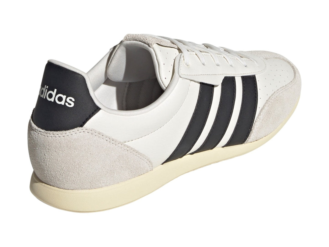 Tenis Adidas Barreda color blanco con tres franjas negras laterales y detalles en gamuza beige.