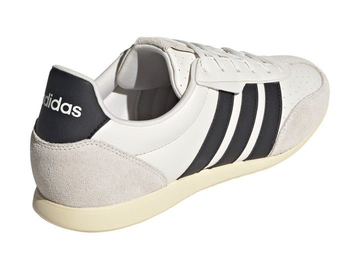 Tenis Adidas Barreda color blanco con tres franjas negras laterales y detalles en gamuza beige.