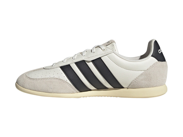 Tenis Adidas Barreda color blanco con tres franjas negras laterales y detalles en gamuza beige.