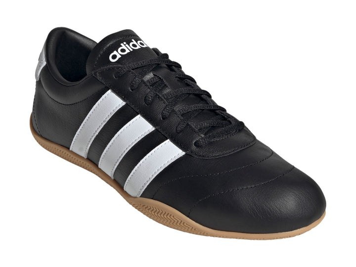 Tenis Adidas Grand Court LO color negro con tres franjas blancas y suela de goma color caramelo.