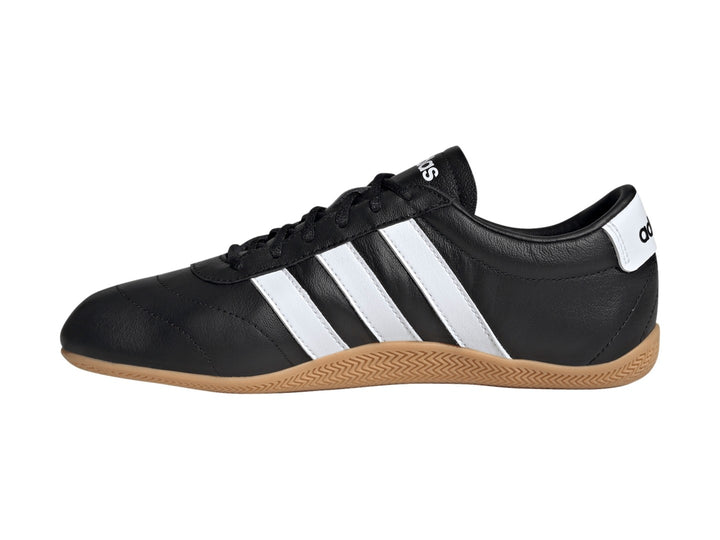 Tenis Adidas Grand Court LO color negro con tres franjas blancas y suela de goma color caramelo.
