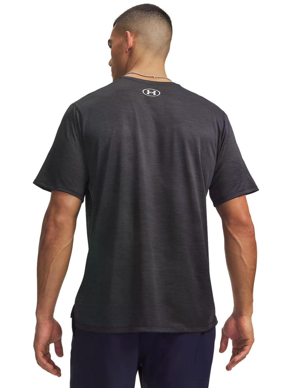 Hombre vistiendo playera deportiva Under Armour Tech Vent de color negro con logotipo blanco en el pecho.