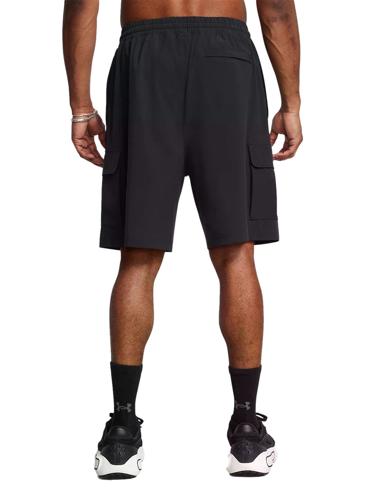 Hombre vistiendo short Under Armour Vibe Cargo color negro con bolsillos laterales y logo blanco.