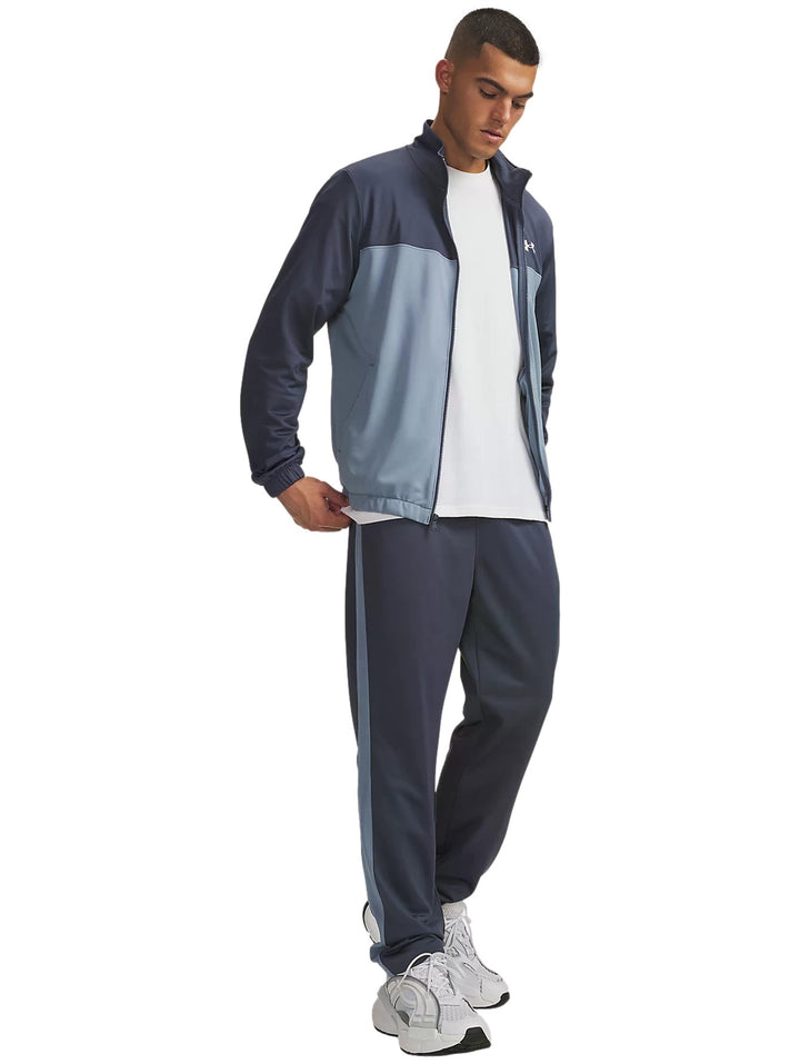 Conjunto deportivo Under Armour en tonos gris y azul compuesto por chaqueta con cremallera y pantalón a juego.