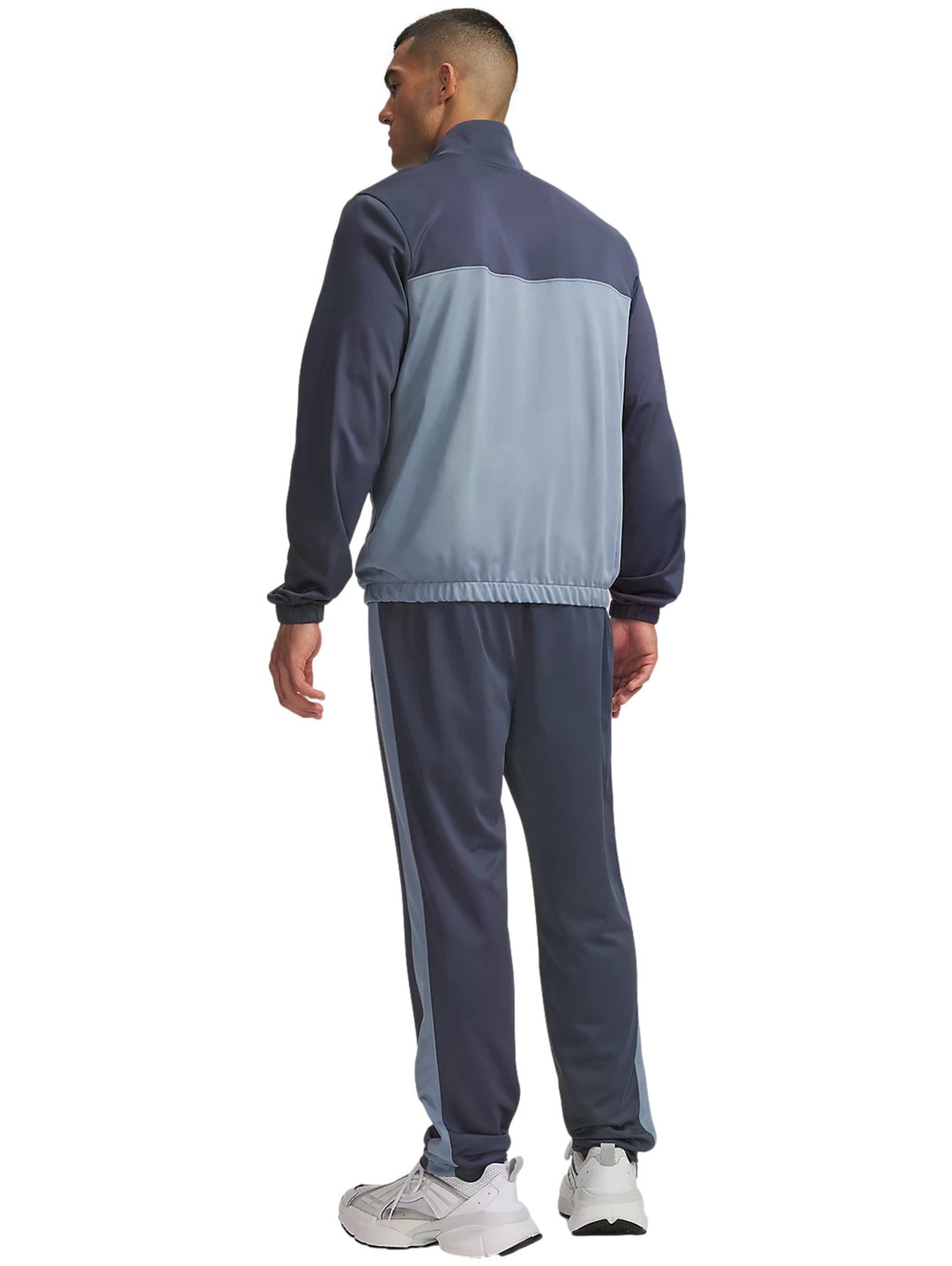 Conjunto deportivo Under Armour en tonos gris y azul compuesto por chaqueta con cremallera y pantalón a juego.