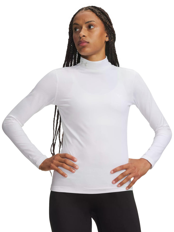 Mujer vistiendo playera deportiva Under Armour ColdGear de manga larga y cuello mock en color blanco.
