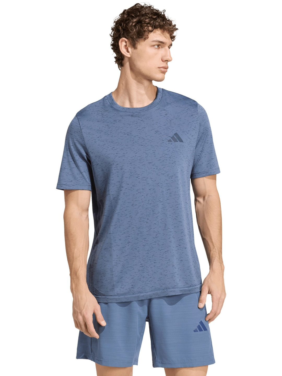 Hombre vistiendo playera y shorts deportivos Adidas en color azul prelov con logo en el pecho.