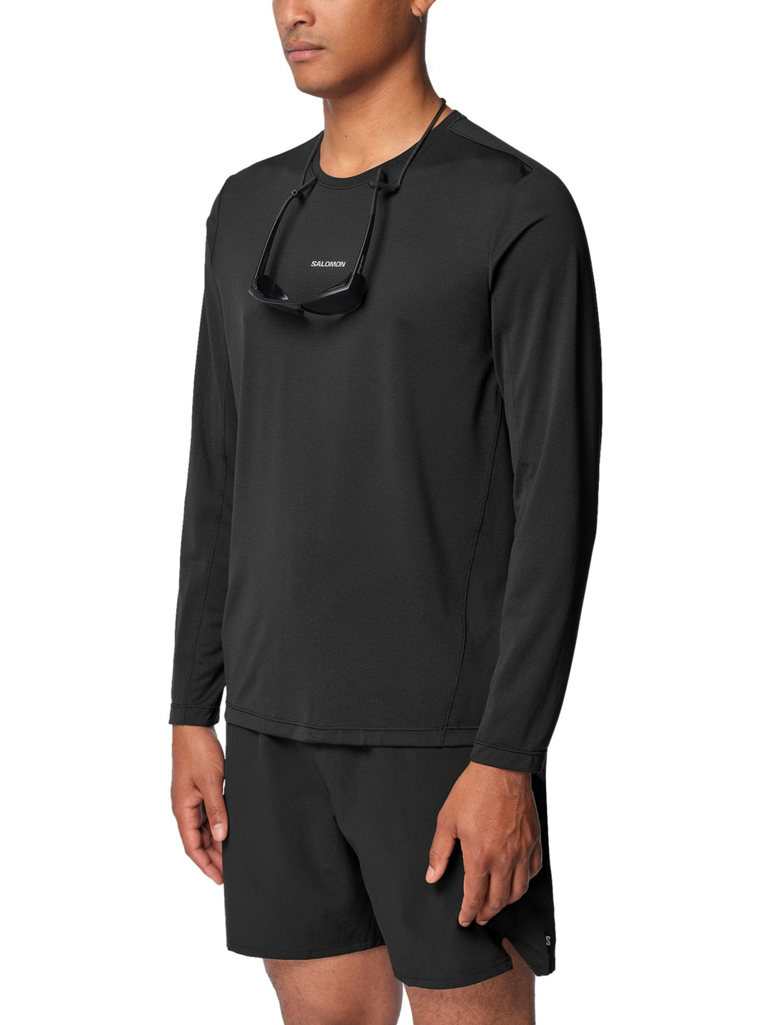 Hombre vistiendo playera deportiva Salomon Shakeout Core de manga larga en color negro.