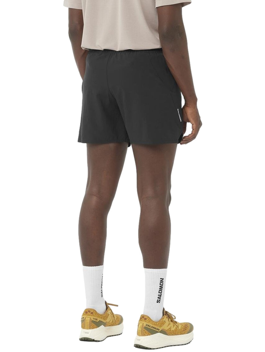 Hombre vistiendo short deportivo Salomon Shakeout Core 5 en color negro con cordón ajustable en la cintura.