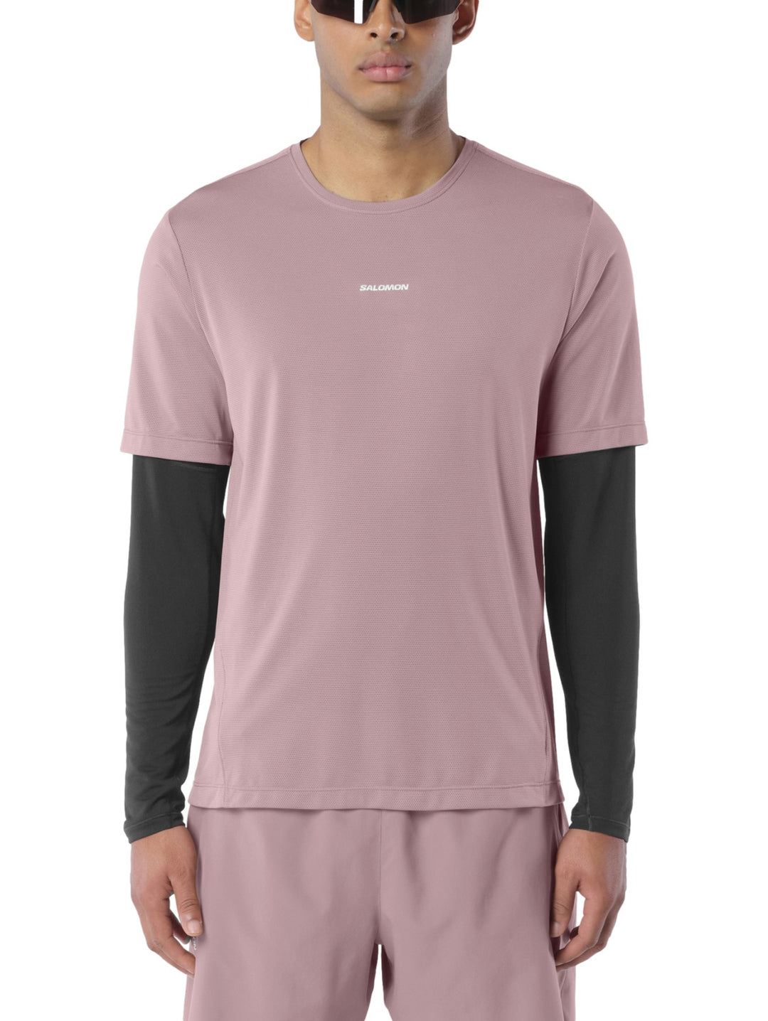 Hombre vistiendo playera deportiva Salomon Shakeout Core color antler con camiseta interior negra y shorts a juego.