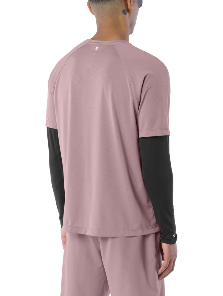 Hombre vistiendo playera deportiva Salomon Shakeout Core color antler con camiseta interior negra y shorts a juego.