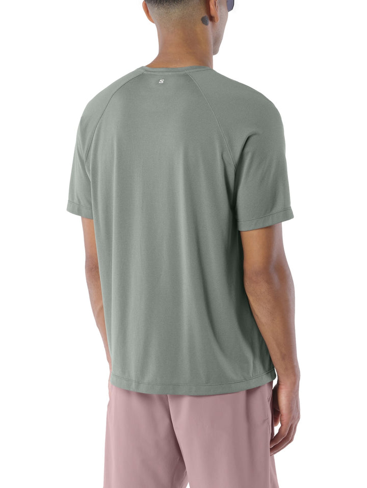 Hombre vistiendo playera deportiva Salomon Shakeout Core en color gris castor con cuello redondo y manga corta.