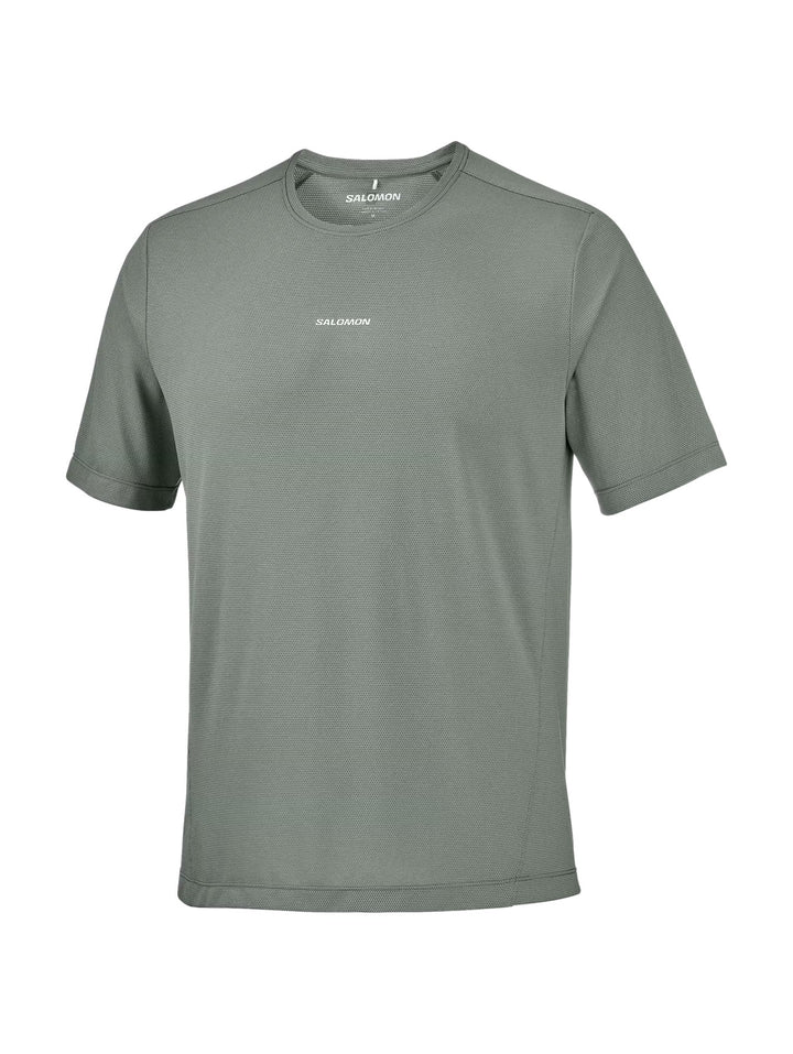Hombre vistiendo playera deportiva Salomon Shakeout Core en color gris castor con cuello redondo y manga corta.