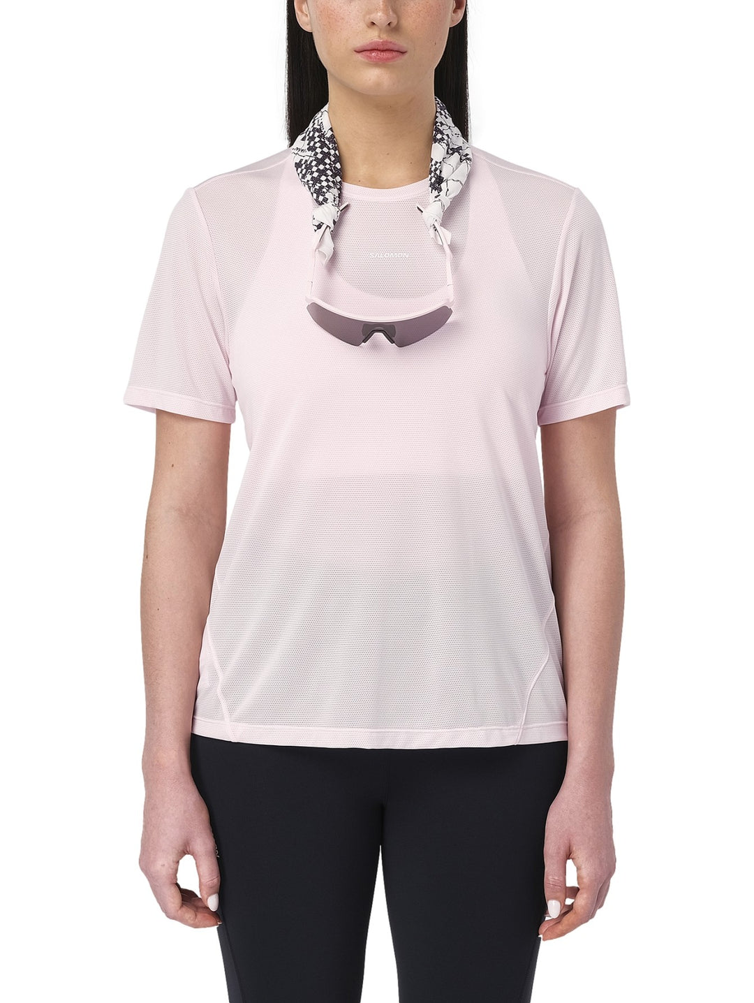 Mujer vistiendo playera deportiva Salomon Shakeout Core en color rosa pálido con tejido transpirable.