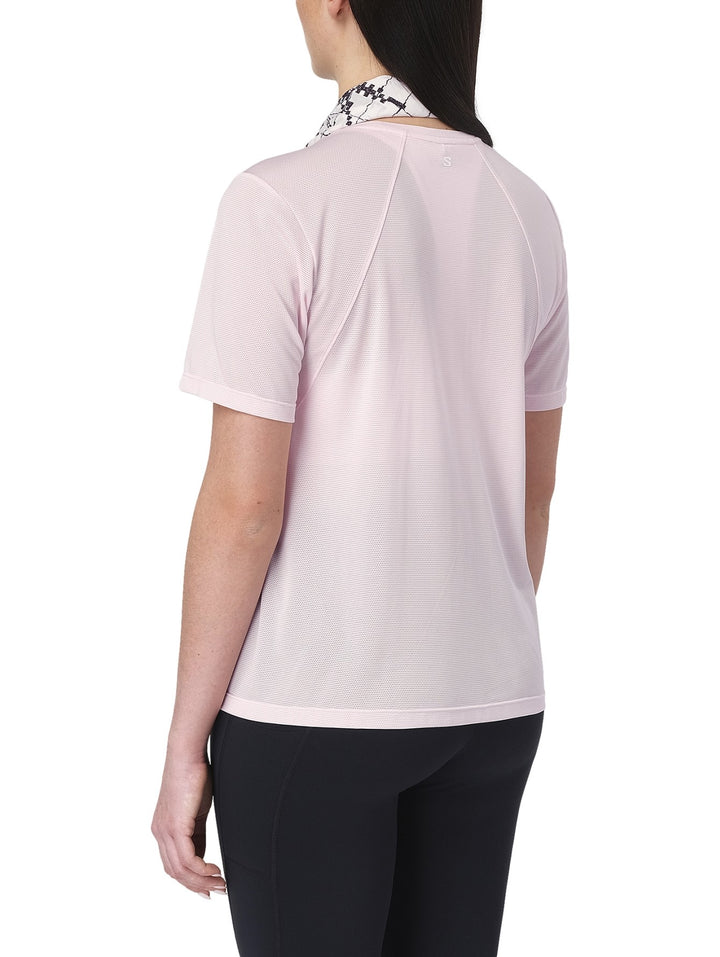 Mujer vistiendo playera deportiva Salomon Shakeout Core en color rosa pálido con tejido transpirable.