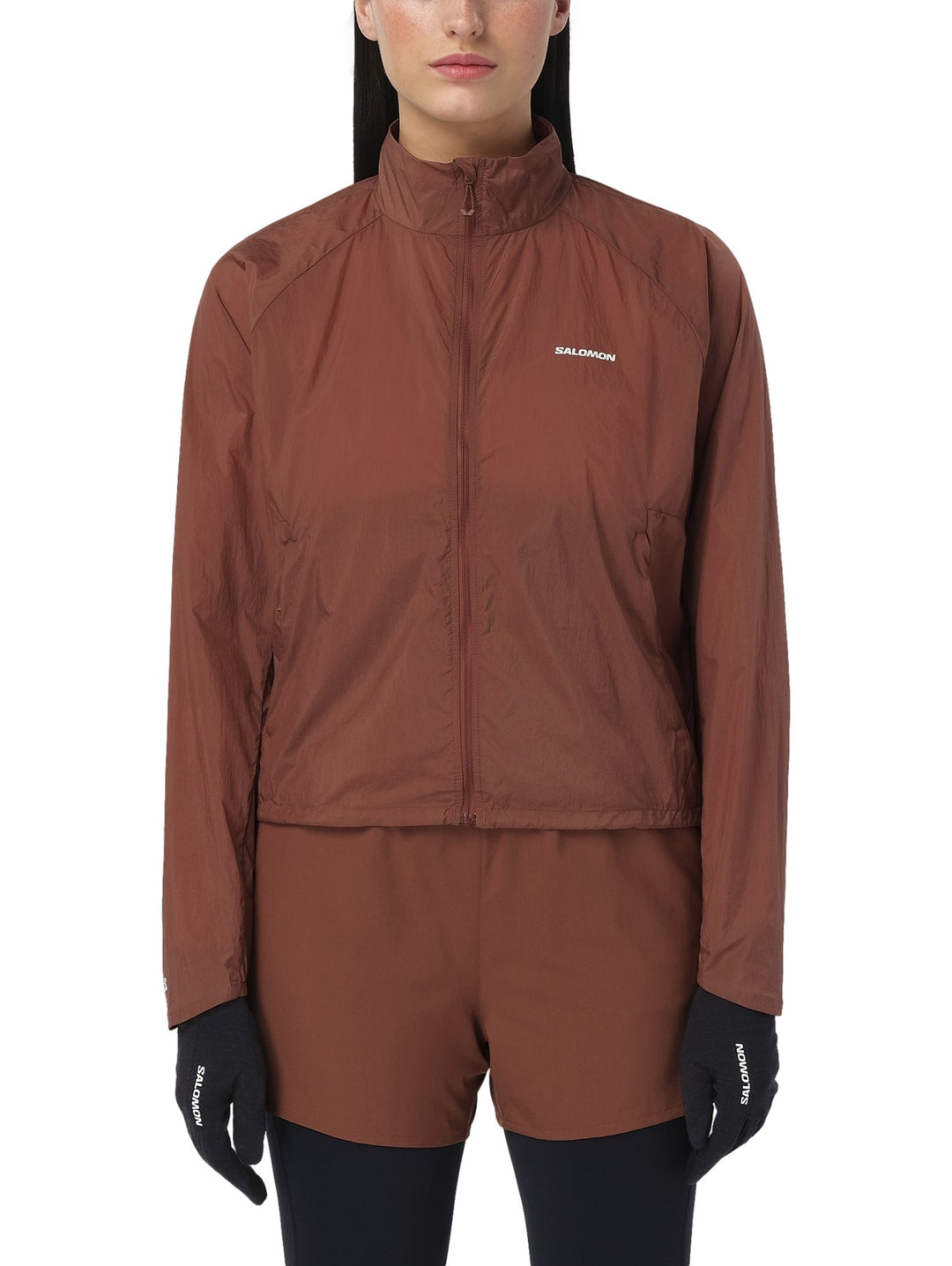 Chaqueta deportiva Salomon Shakeout Fly en color Burnt Umber con cierre frontal y cuello alto.